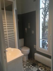 a bathroom with a toilet and a sink and a window at Meudon : idéal pour séjour à Paris in Meudon