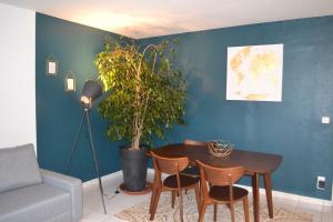 uma sala de estar com uma mesa e um vaso de plantas em Meudon : idéal pour séjour à Paris em Meudon