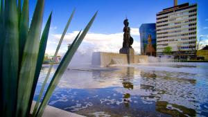 a fountain in a city with a statue in the water at Hotel San Juan in Guadalajara
