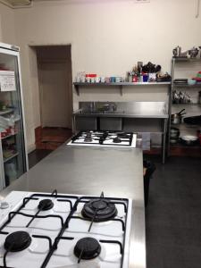 a kitchen with a stove top oven in a kitchen at Shingo's Backpackers in Adelaide