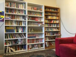a library with white book shelves filled with books at Shingo's Backpackers in Adelaide