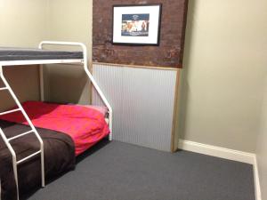 een kleine kamer met een stapelbed en een muur bij Shingo's Backpackers in Adelaide