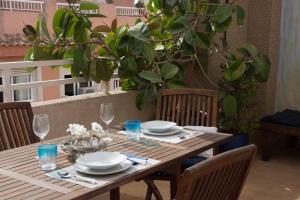 a wooden table with plates and glasses on top of it at Lovely Penhouse in Alicante with parking in Alicante