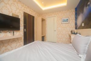埔里鎮的住宿－沃特弗朗，卧室设有一张大白色床和电视。