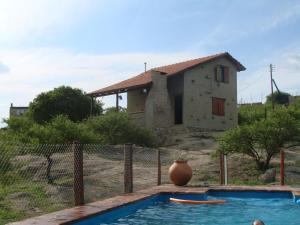 una casa con un jarrón sentada junto a una piscina en Cabañas las Vertientes in 