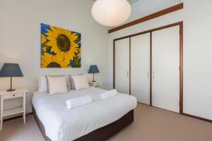 
a bedroom with a bed and a lamp at Cottesloe Sea Salt Abode in Perth

