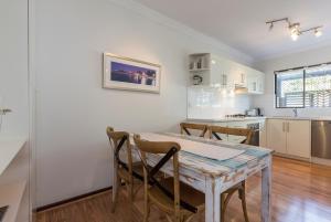 a kitchen and dining room with a table and chairs at Cottesloe Sea Salt Abode in Perth