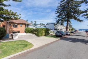 a house with cars parked on the side of a street at Cottesloe Sea Salt Abode in Perth