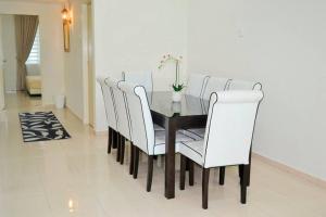 a dining room with a table and white chairs at CASA ADELIA HOMESTAY KEMAMAN in Cukai +12 photos