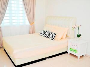 a white bed with a zebra pillow on it in a room at CASA ADELIA HOMESTAY KEMAMAN in Cukai