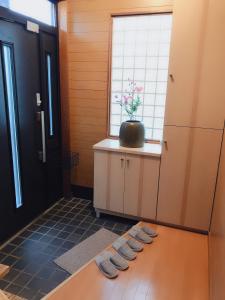 a room with a kitchen with a window and some towels at Guest House Asahi in Otaru
