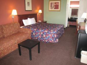 Habitación de hotel con cama y sofá en Motel 8 Maricopa, en Maricopa