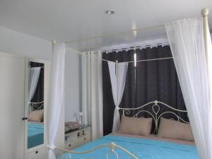 a bedroom with a canopy bed and a mirror at Similan Hotel in Bang Tao Beach