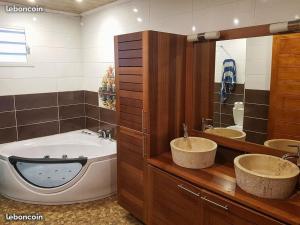 a bathroom with two sinks and a large tub at lilie97418 in La Plaine des Cafres +31 photos