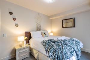 a bedroom with a bed and a table with a lamp at Alpine Village - 2 Bedroom Executive Apartment in Queenstown