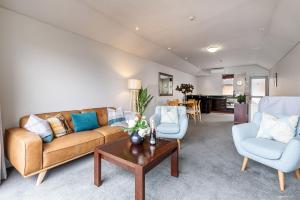 a living room with a couch and two chairs and a table at Alpine Village - 2 Bedroom Executive Apartment in Queenstown