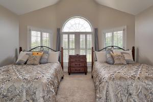 two beds in a bedroom with two windows at Pleasanton Courtyard Bed and Breakfast in Fayetteville
