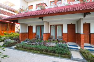 a house with a garden in front of it at Sinar Bali Hotel in Legian