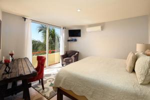 a bedroom with a bed and a table and a window at Villas Piedra Blanca in Sayulita