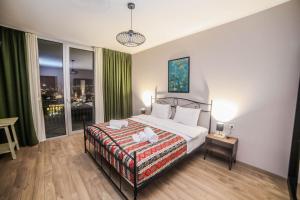 a bedroom with a bed and a large window at Hotel Flower in Tbilisi City