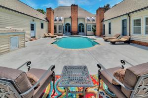a backyard with a pool and chairs and a house at Pleasanton Courtyard Bed and Breakfast in Fayetteville