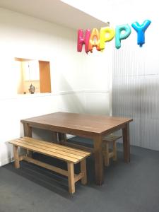 a wooden table and bench with a happy birthday sign at Shingo's Backpackers in Adelaide