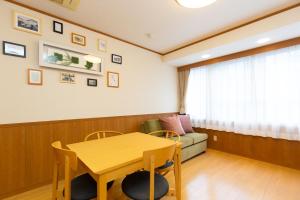 a dining room with a table and a couch at Matsui Building in Tokyo