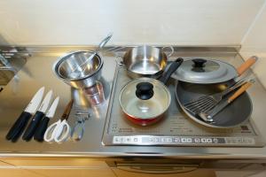 a stove top with pots and pans and utensils at Matsui Building in Tokyo