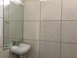 a white bathroom with a sink and a mirror at Shingo's Backpackers in Adelaide +6 photos