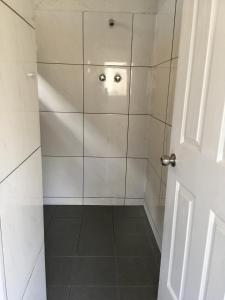 a shower with a glass door in a bathroom at Shingo's Backpackers in Adelaide