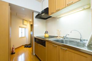 a kitchen with wooden cabinets and a sink at Matsui Building in Tokyo