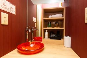 a bathroom with a red bowl sink on a counter at Matsui Building in Tokyo