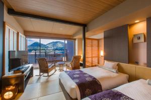 a hotel room with two beds and a balcony at Migiwatei Ochi Kochi in Fukuyama