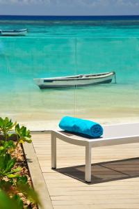 Una almohada azul sentada en un banco junto a la playa en OBiches Luxury Beachfront Apartment Trou-aux-Biches, en Trou aux Biches