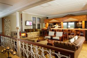 a living room with a couch and a bar at Queens Hotel by BON Hotels in Oudtshoorn