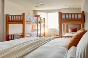 小谷村的住宿－Canopy Lodge - Boutique Lodge at Hakuba Cortina，一间卧室设有两张双层床和一扇窗户。