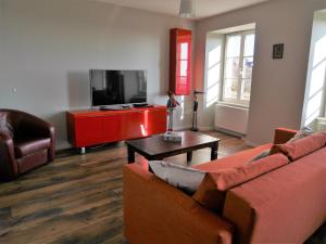 a living room with two couches and a flat screen tv at Les gîtes de la Tour, appartement "La Plaine" in Saint-Hippolyte