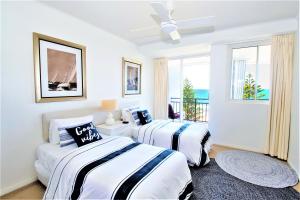 twee bedden in een witte kamer met een raam bij Indigo Blue in Gold Coast +22 foto's