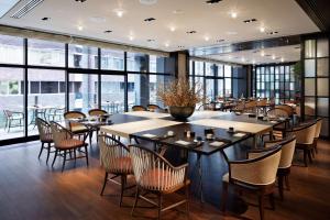 a dining room with tables and chairs and windows at Hyatt Centric Ginza Tokyo in Tokyo