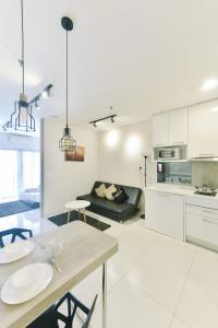 a white kitchen and living room with a table and chairs at Summer Suites Residences by Subhome in Kuala Lumpur