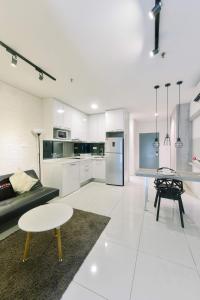 a white living room with a table and a kitchen at Summer Suites Residences by Subhome in Kuala Lumpur