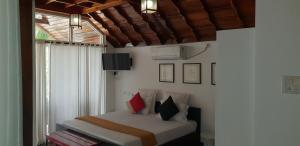 um quarto com uma cama com almofadas vermelhas e pretas em Petit Elephant em Cherai Beach
