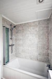 uma banheira branca na casa de banho com uma janela em STABLE HOUSE - Eton WINDSOR em Windsor