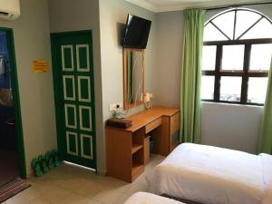 a bedroom with a desk and a bed and a mirror at Kangsar Hotel in Kuala Kangsar