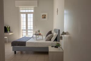 a bedroom with a bed with a table and a window at Casa F.A.C.I in Marina di Massa