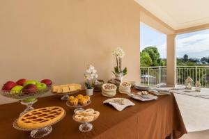 un tavolo con cibo e cesti di frutta e pane di Villa Furoa a Quartu SantʼElena