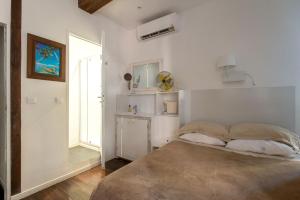 アジャクシオにあるRésidence 18Bonaparteの白いベッドルーム(ベッド1台、窓付)
