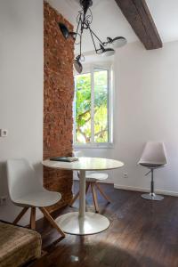 アジャクシオにあるRésidence 18Bonaparteのテーブルと椅子2脚、窓が備わる客室です。