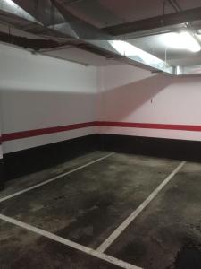 een lege parkeergarage met een rode en witte muur bij PISO 20 in Candelaria