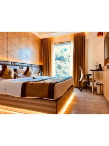 a bedroom with a bed with a desk and a window at JRD Pride in New Delhi